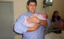 O papai Sandro, orgulhoso, com  a filhota nos braços 